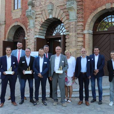 Die Preisträger und Laudatoren (vorne, von links) Rene Wenzel (2022, K.I.S. Kran- und Industrieservice GmbH), Ingo Slomski und Thomas Köhler (2022, Greve Innenausbau GmbH), Frank und Martina Speck (Schlachtbetrieb Möllin). (hinten von links) Landrat Tino Schomann, die Laudatoren Manuel Krastel, Heiner Wilms und Jörg Denecke, WFG-Geschäftsführer Martin Kopp.