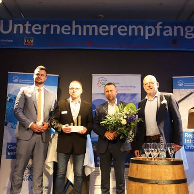 Landrat Tino Schomann, die Preisträger 2022 Ingo Slomski und Thomas Köhler (Greve Innenausbau GmbH), Laudator Heiner Wilms.