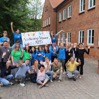 Elf junge Leute aus ganz Europa und sogar aus Mexiko verbringen zwei Wochen in Nordwestmecklenburg, um soziale Arbeit vor Ort zu unterstützen. © Landkreis Nordwestmecklenburg Auf dem Bild ist eine Gruppe von Menschen aus ganz Europa zu sehen. Alle jubeln und strecken die Hände in die Höhe.