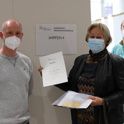 Nach ihrer Auffrischungsimpfung durch Impfarzt Roman Stiefel überreichte Impfmanager Tom Brose zur Erinnerung an die 100.000. Impfung im Landkreis eine Urkunde Karin Harder (81).