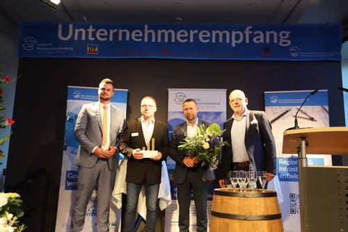 Landrat Tino Schomann, die Preisträger 2022 Ingo Slomski und Thomas Köhler (Greve Innenausbau GmbH), Laudator Heiner Wilms.