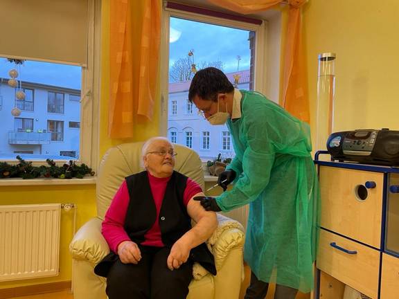 Dr. Fabian Holbe führte die Impfung bei Getrud Brötzmann (88) im Beisein von Landrätin Kerstin Weiss im Seniorenhaus in Kalsow durch.