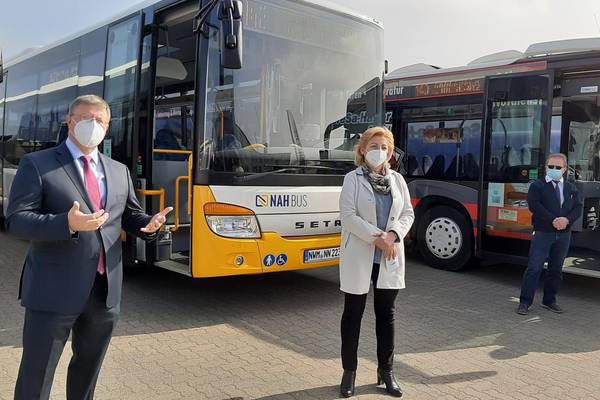 Bei einem Pressetermin am 25. März stellte NAHBUS, das Nahverkehrsunternehmen des Landkreises Nordwestmecklenburg, seine Tätigkeiten zur Erneuerung seiner Busflotte und Modernisierung des Nahverkehrs der Öffentlichkeit vor. Im Beisein von Landrätin Kerstin Weiss präsentierte Geschäftsführer Jörg Lettau dabei zwei neu angeschaffte Busse der Marke Setra mit einer Länge von 12 und 15 Metern. Sie sind Teil einer Gesamtanschaffung von 30 Bussen – 15 davon in 2020 und 15 weitere folgen in 2021. „Wir arbeiten ständig daran, unsere Flotte zu modernisieren, um den Nutzern des Nahverkehrs mehr Komfort und Service zu bieten und auch ökologischer zu werden. In den letzten 5 Jahren haben wir rund 50 Prozent unserer Busflotte erneuert.“, so Jörg Lettau. Landrätin Kerstin Weiss unterstrich das an einem Beispiel: „14 der neu angeschafften Busse haben einen Gasantrieb, neun davon sollen ab Juni 2021 zusätzlich im Wismarer Stadtverkehr zum Einsatz kommen. Durch die geringere Abgasbelastung wird das auch zu einer Verbesserung der Lebensqualität in der Stadt beitragen. Nur noch drei Busse in Wismar werden dann noch auf Diesel laufen.“ Gemäß Investitionsplan sollen im April 2022 acht weitere Gas-Busse folgen. Aber auch neu angeschaffte Diesel-Fahrzeuge haben dank AdBlue-Technologie, die der Abgasnorm 6 entspricht, einen um bis zu 90 Prozent reduzierten Stickoxid-Ausstoß im Vergleich zu älteren Modellen. Auch für die Barrierefreiheit wird mit den neuen Anschaffungen gesorgt, denn natürlich sind alle neu gekauften Modelle so genannte „Niederflurbusse“ mit ausklappbarer Rampe. 2022 sollen alle Busse der NAHBUS diesem Standard entsprechen. Bei einer Rundfahrt mit einem nachgerüsteten Bus konnten sich die Journalisten von der tadellosen Funktionsweise der neuen Innen-Anzeigetafeln überzeugen, auf denen gut lesbar die nächste Haltestelle und der weitere Streckenverlauf angezeigt wird. Dank eingebauter Bordcomputer mit GPS weiß die Zentrale nun jederzeit auf den Meter genau, wo sich die Busse befinden. Ein wichtiger Faktor für weitere Maßnahmen zur Kundenfreundlichkeit, die der Nahverkehrskoordinator des Landkreises Tino Waldraff erklärte: „Wir setzen derzeit die Installation von zunächst Fahrgastinformationssystem an wichtigen Haltepunkten um, wie zum Beispiel dem ZOB in Wismar. Dank der Bordcomputer kann dann dort angezeigt werden, wann genau der Bus kommt, wie es schon in vielen Großstädten der Fall ist.“, so Waldraff. Außerdem wird mit Hochdruck an einer APP gearbeitet, die ebenfalls auf diese Daten zugreifen soll – Fahrgastinformation für die Hosentasche. Auch Projekte wie ein elektronisches Ticket und das bargeldlose Bezahlen sind in Vorbereitung. Die Modernisierungs-Umbauten werden auch bei den Partner und Auftragnehmern von NAHBUS umgesetzt. Bis Ende Mai sollen Bordcomputer und Anzeigetafeln im kompletten Fuhrpark von NAHBUS nachgerüstet sein. In Zusammenarbeit mit NAHBUS und den Gemeinen arbeitet man außerdem man außerdem daran, das Haltestellen-Netzwerk zu Modernisieren und auch baulich an die Erfordernisse eines modernen, kundenorientierten Nahverkehrs anzupassen. © LK NWM 20210326 NAHBUs Busflotte1